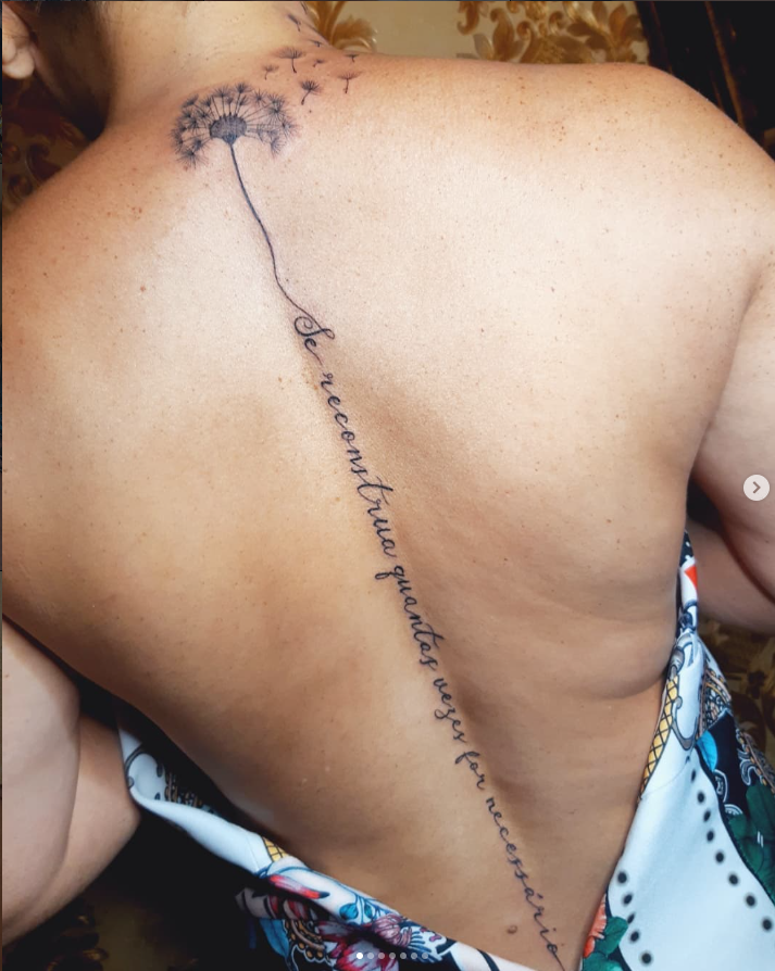 Tatuagem delicada de dente-de-leão e frase minimalista nas costas